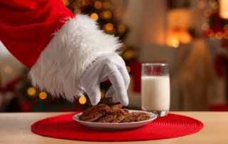 Merry,Christmas.,Santa,Claus,Taking,Cookies,From,Plate,On,Table