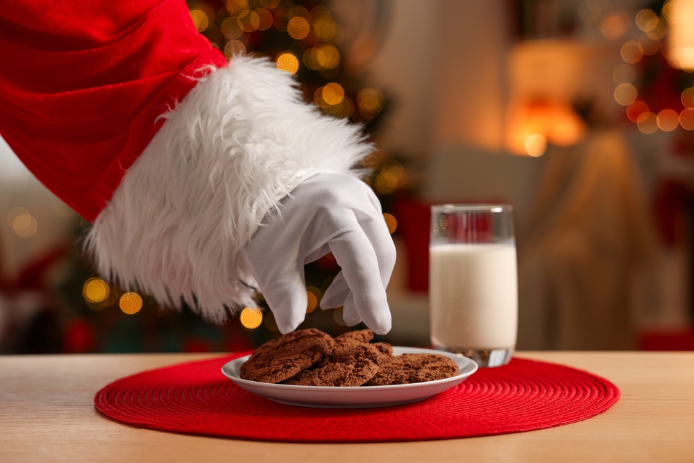 Merry,Christmas.,Santa,Claus,Taking,Cookies,From,Plate,On,Table